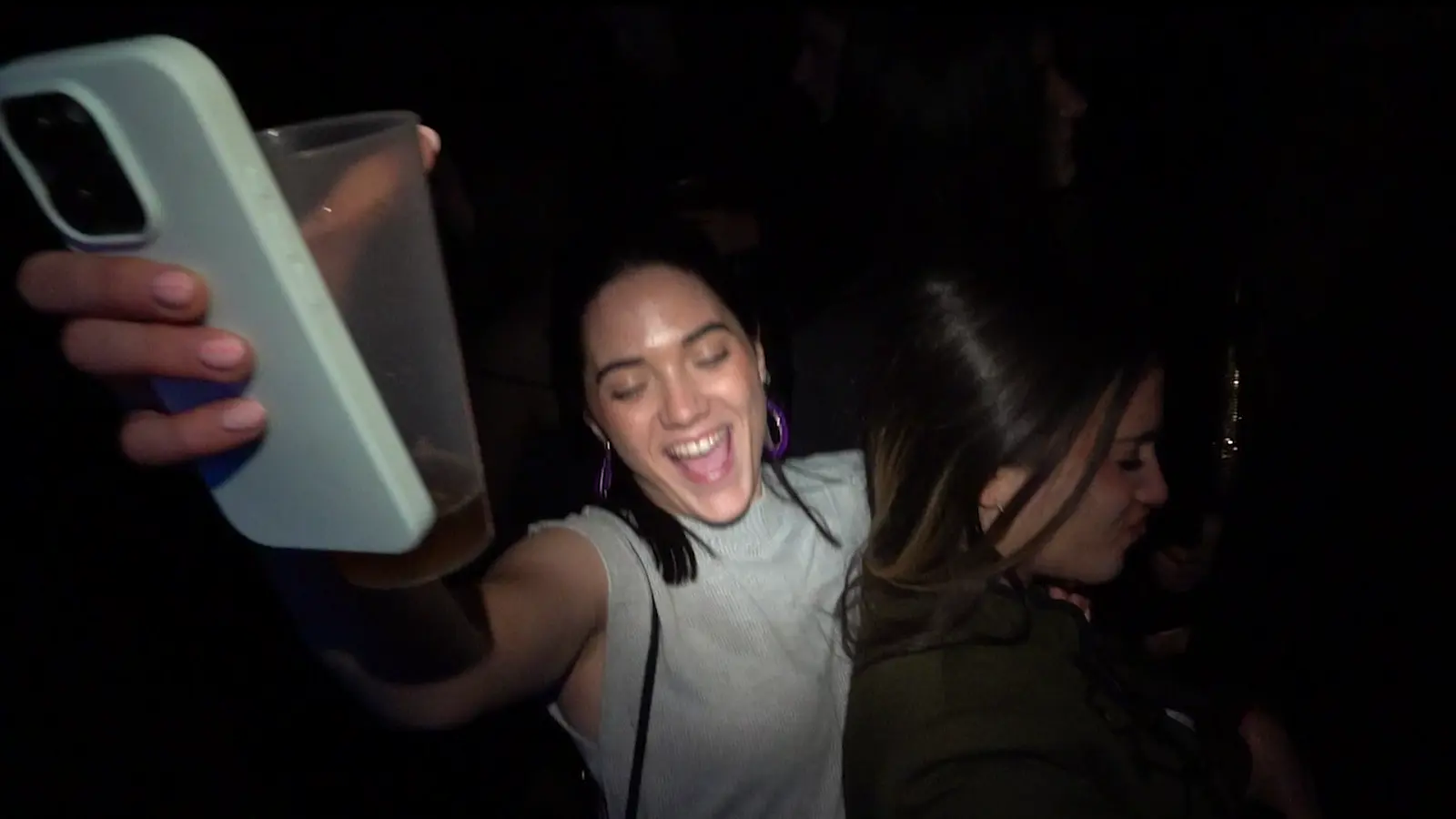 Dos chicas brindando con el vaso en alto